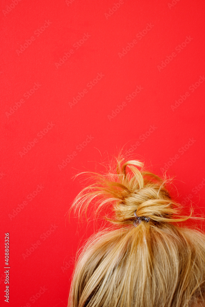 Naklejka premium Blonde hair bun on the red background