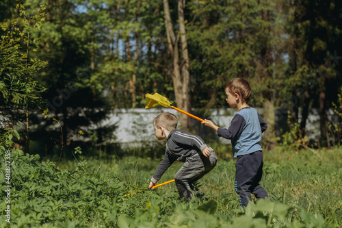 Two boys with butterfly nets in countryside. Image with selective focus