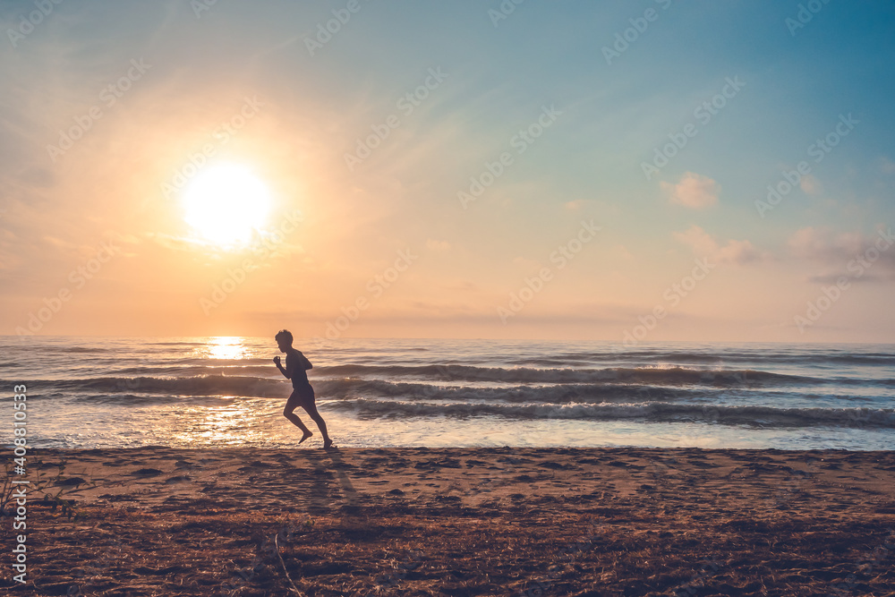 silhouette of jogging man on beach in the morning at sunrise.