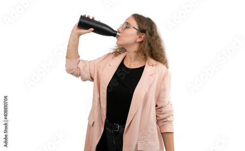 A woman in a suit is drinking from a reusable water bottle. White background.