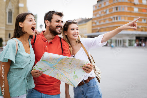 Happy traveling tourists sightseeing with map and having fun photo