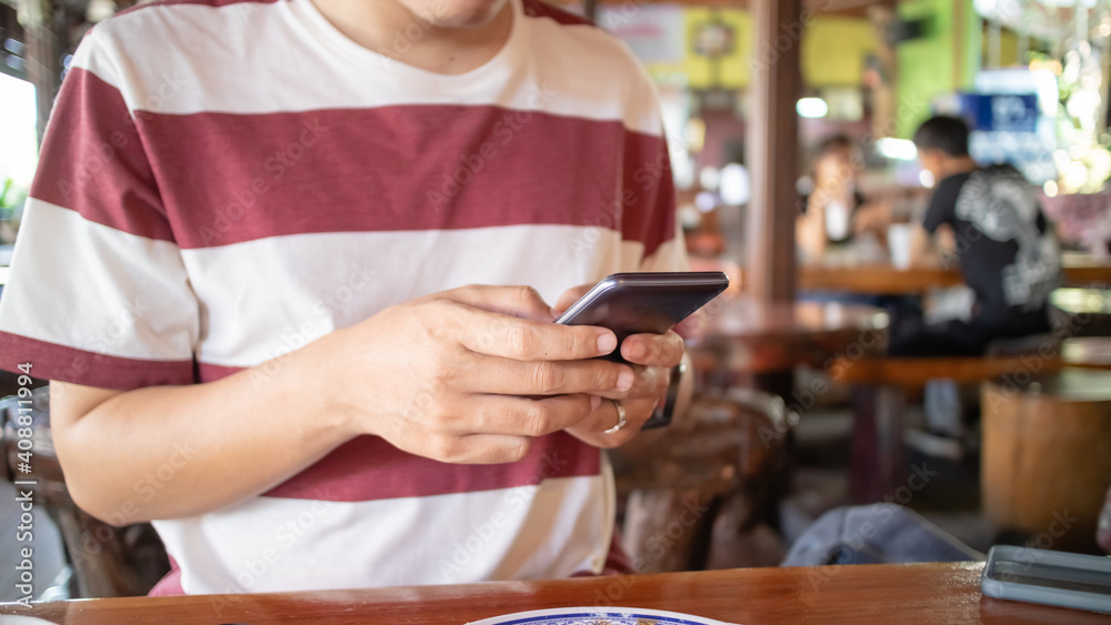 Man using smartphone in restaurant.