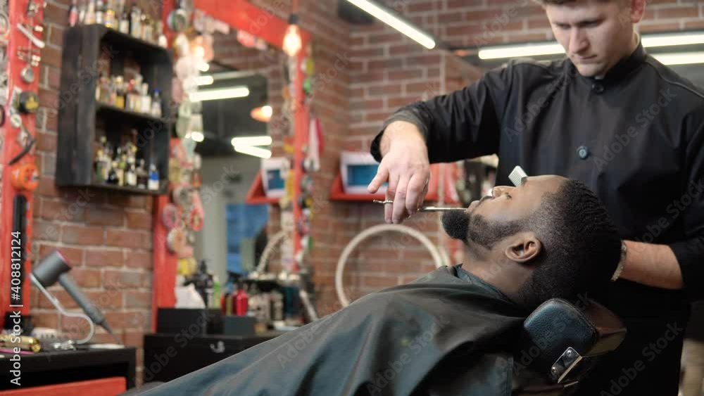 The hairdresser cuts with scissors and combs the client's beard with a comb. Beard care The hairdresser cuts with scissors and combs the client's beard with a comb. Beard care