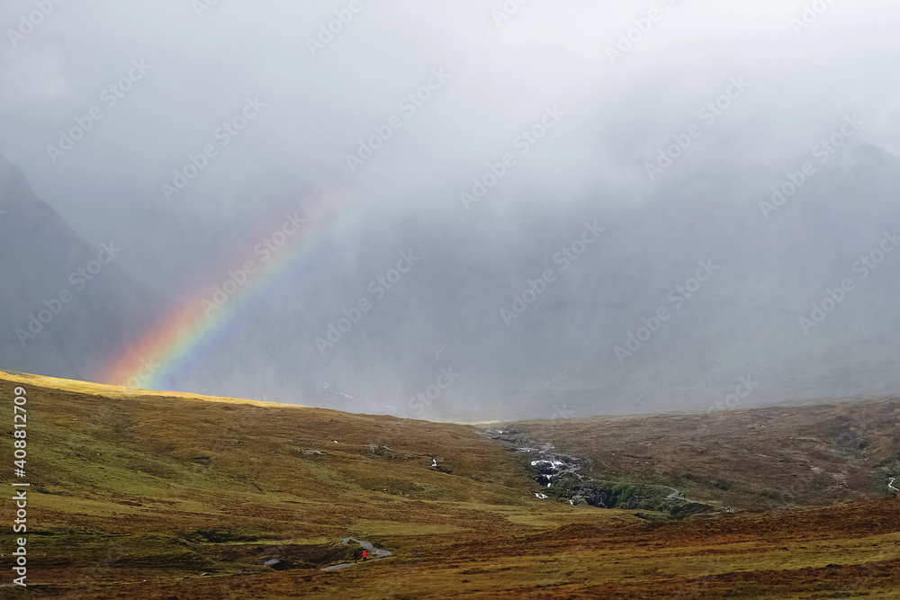 Scenic view to Scottish highlands with rainbow through the clouds