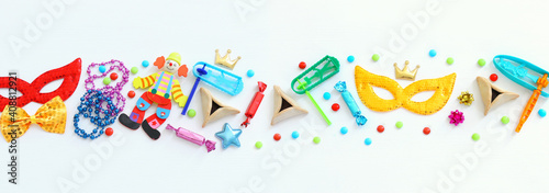 Purim celebration concept (jewish carnival holiday) over wooden white background. Top view, flat lay