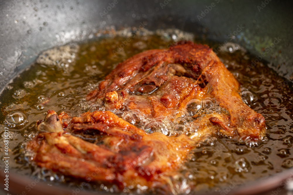 Fry the chicken in a pan with boiling oil. Fry the chicken in a pan with boiling oil.