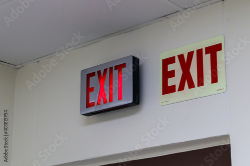 red emergency exit sign in the dark room. illuminated office exit sign.