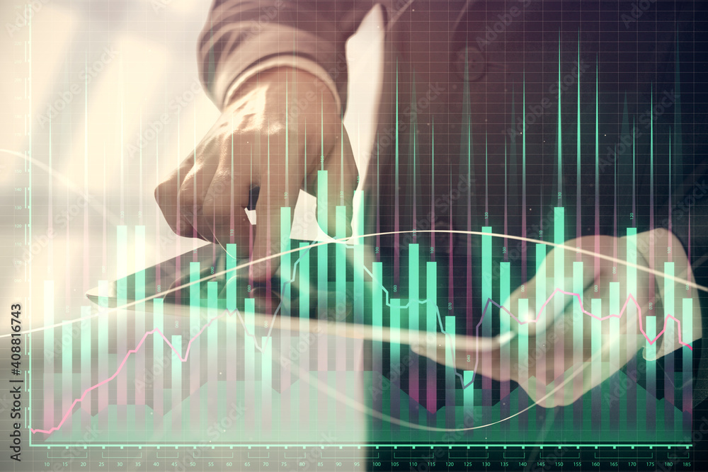 Double exposure of man's hands holding and using a digital device and forex graph drawing. Financial market concept.