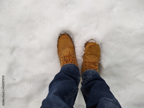 first person view man bend down the head looking for his boots standing on snow