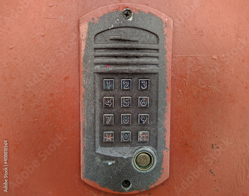 old push button intercom on the wall of the entrance door of a multi storey building