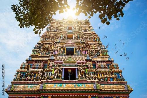 Traditional Hindu temple Kidangamparambu Sree Bhuvaneswari in India in Allapuzha (Allepi) Kerala. Tall building with colorful figures of Indian mythology and gods, flock of live birds. Tourism, travel photo