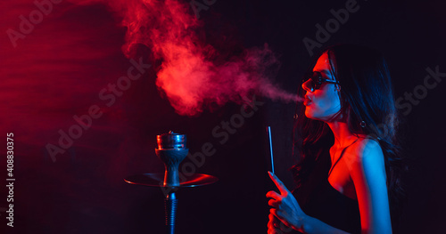 Hookah atmosphere. The girl enjoys smoking a hookah  sheesha. Place for your text