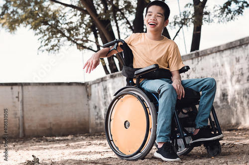 Disabled child on wheelchair is playing, learning and exercise in the outdoor like other people with parent,Nature background,Lifestyle of special child in education age, Happy disability kid concept.