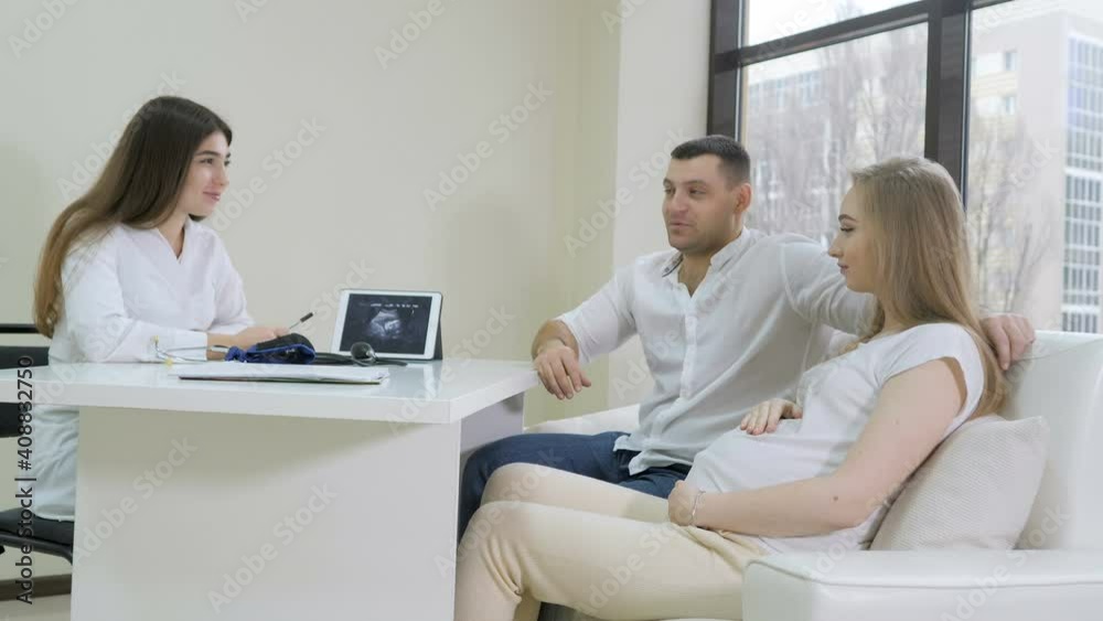 Expectant couple talking while counsulting doctor in clinic