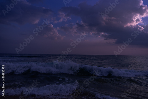Fioletowo różowe niebo, krajobraz zachodzącego słońca na tle tropikalnej plaży i oceanu. © insomniafoto