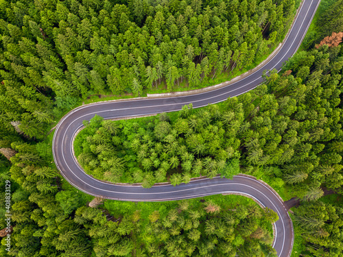 Winding road through the forest, from high mountain pass, in summer time. Aerial view by drone. Romania © Rafaila Gheorghita