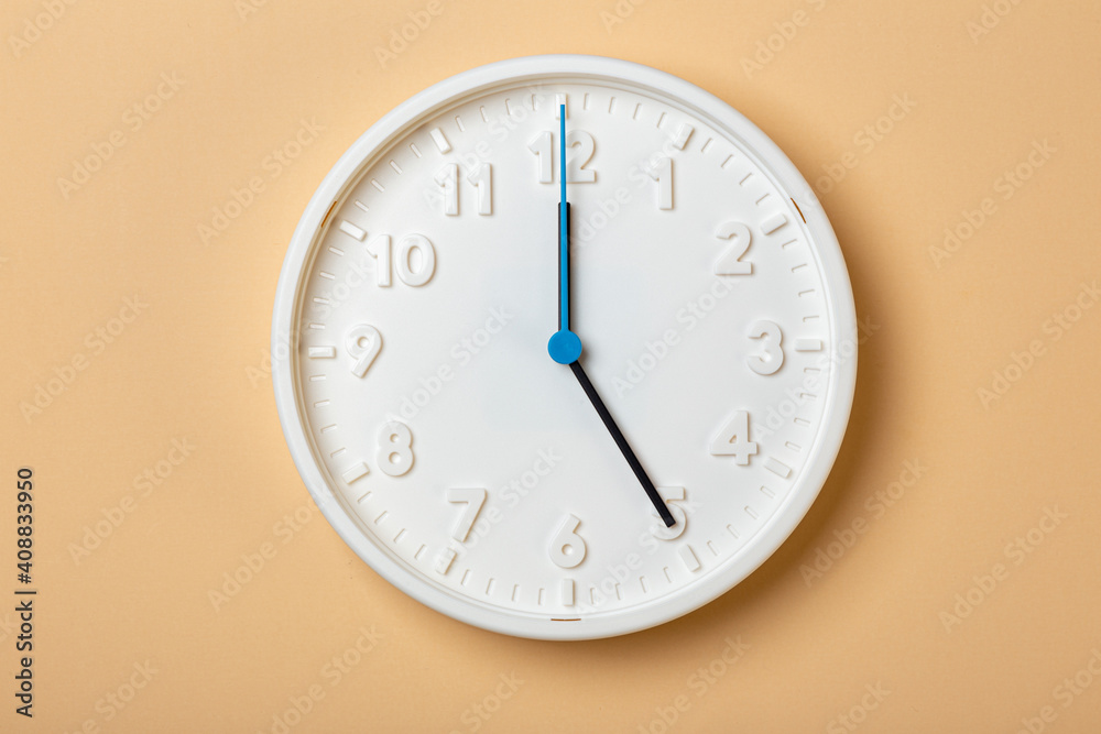 white wall clock with blue second hand show five o'clock white wall clock with blue second hand show five o'clock