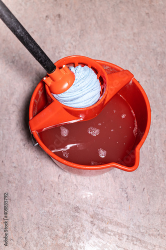 Obraz na plátně top view of squeezing mop in red bucket with dirty water at home