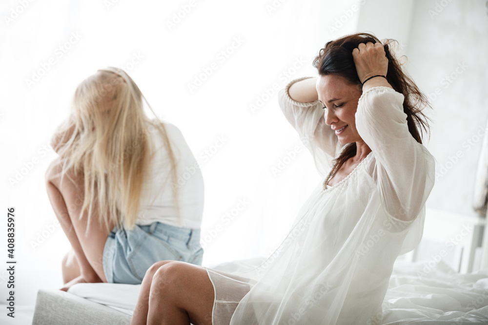 Family conflict and relations concept. Mother and daughter having quarrel and aguring at home. Sad woman and teenage girl sitting on bed. Not looking at each other Family conflict and relations concept. Mother and daughter having quarrel and aguring at home. Sad woman and teenage girl sitting on bed. Not looking at each other
