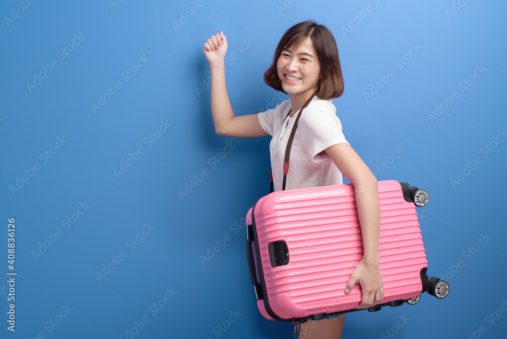 Portrait of young female traveler isolated over purple background studio.