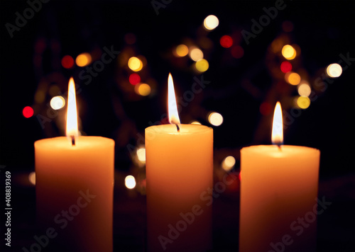 close up flame candles with decorative lights on a bokeh black background