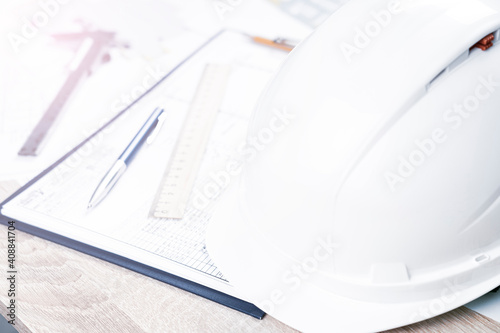helmet and tools for construction drawings and construction drawings close-up, selective focus, tinted image, architectural design concept, construction and repair work