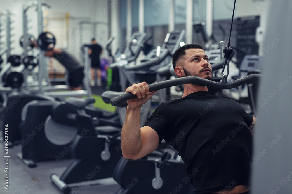 Bodybuilder working out in gym with determination Bodybuilder working out in gym with determination