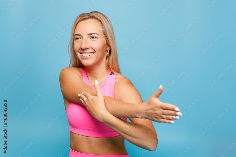 Portrait of a young fitness girl doing exercises isolated on a blue background Portrait of a young fitness girl doing exercises isolated on a blue background