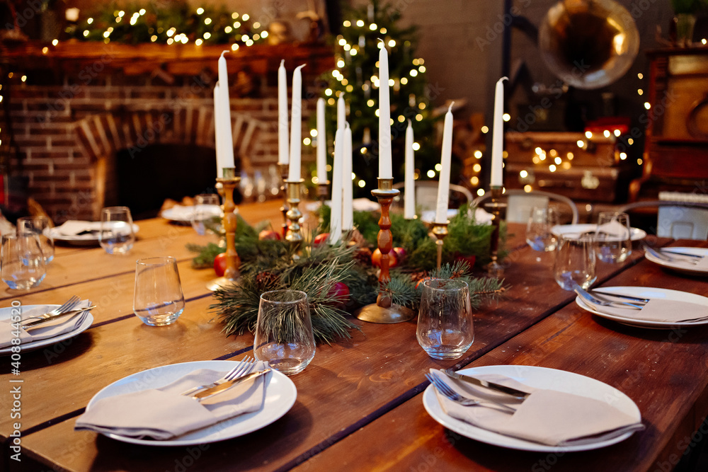 Fototapeta premium large square wooden table served for Christmas dinner. retro styled. Low light.