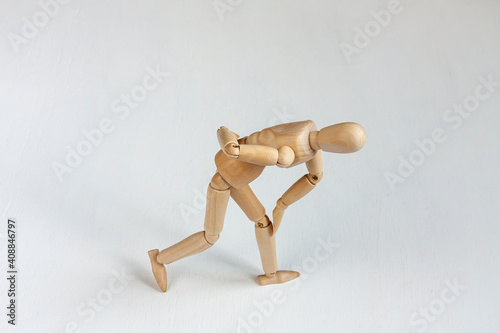 a bent wooden mannequin suffering from backache