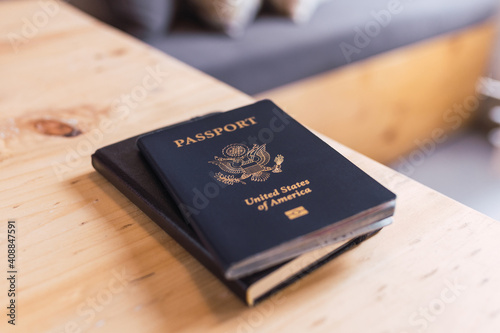A blue American passport sitting on top of a small black notebook while at a coffee shop