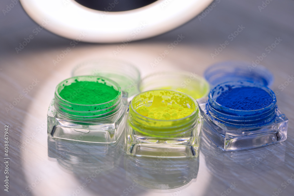 Jars of dry multi-colored pigments in a nail salon for nail design. Jars of dry multi-colored pigments in a nail salon for nail design.