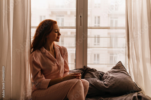 Foto Debonair woman in pajama sitting on bed