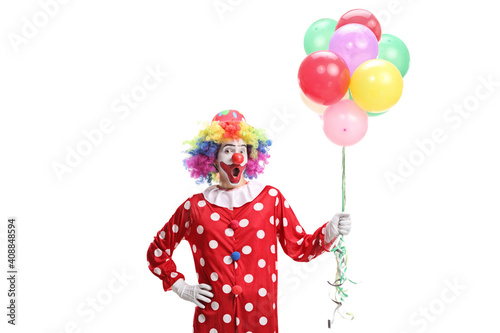 Surprised clown holding a bunch of balloons