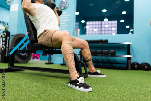 Strong man with tattoos prepares training in the gym to compete photo