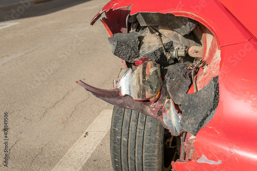 Close-up of a damaged headlamp of a red car