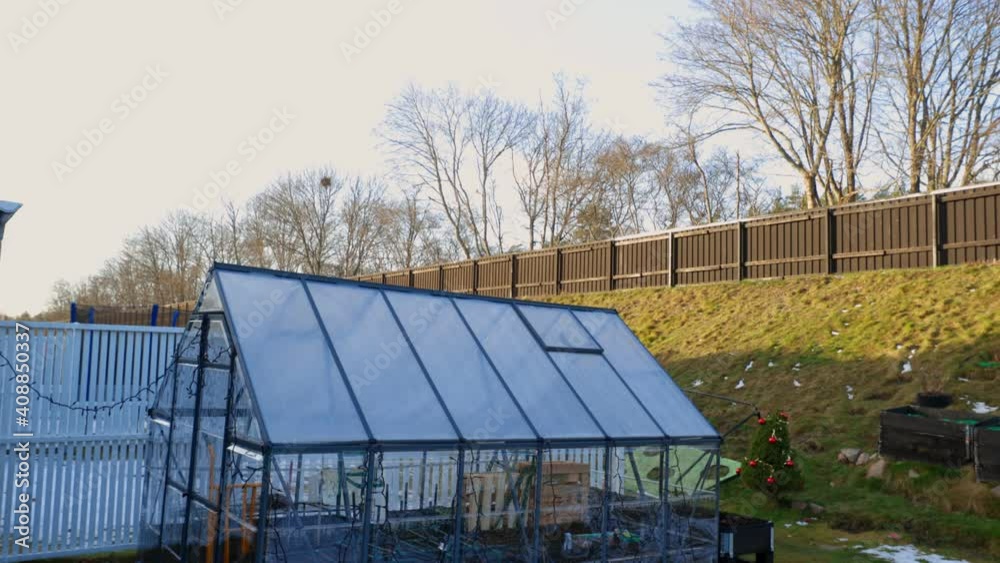 Beautiful landscape view of back yard on warm spring day. Greenhouse on backyard on green landscape background. Beautiful landscape view of back yard on warm spring day. Greenhouse on backyard on green landscape background.