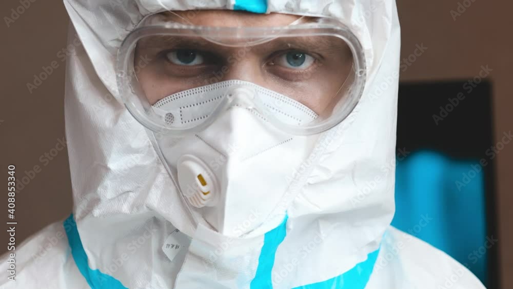 Young man in epidemiological uniform and glasses in hospital