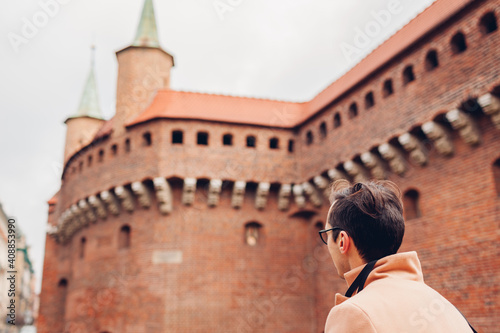 Tourist looking at Barbikan gate in Krakow city, Poland. Barbakan museum. Man enjoys sightseeing photo