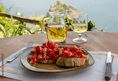 Italian bruschetta and white wine against the background of the Aragonese castle, Ischia island, Italy
