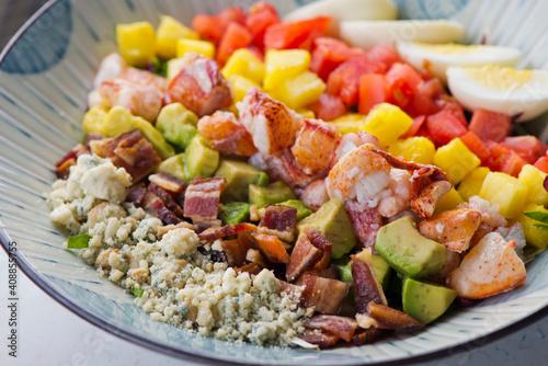 Cobb salad. Classic American restaurant or French bistro Cobb salad, made with chopped Bibb or Romain lettuce, heirloom tomatoes, bacon, blue cheese, avocado, hard boiled eggs tossed with olive oil.