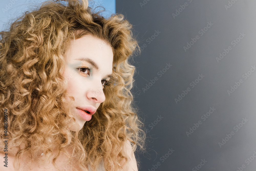 Fototapeta premium Mirrored reflection face of young curly blond woman