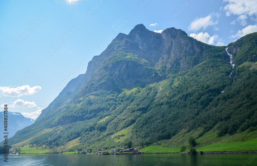 Mountains waterfall and fjord Sognefjord in Norway. Clouds and blue sky. Beautiful stunning views of mountains, water, sky, clouds and sun. Norwegian nature Mountains waterfall and fjord Sognefjord in Norway. Clouds and blue sky. Beautiful stunning views of mountains, water, sky, clouds and sun. Norwegian nature