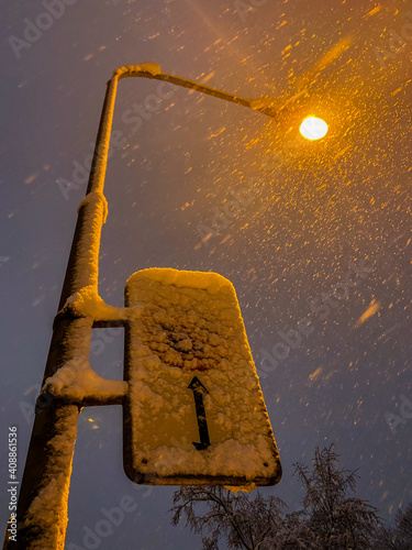 a snowy street sign and a lantern