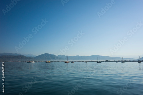 Seascape with calm blue water, yachts and mountains on horizon in Fethiye bay, Turkey. Sunny day perfect blue sky © art_of_line