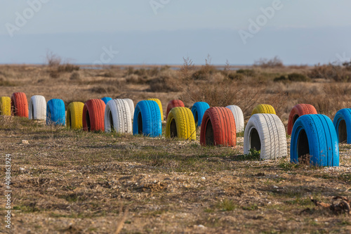 Tires painted in different colors buried in the ground