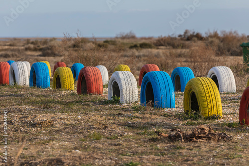 Tires painted in different colors buried in the ground