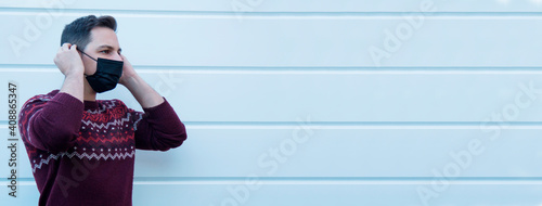 young man with medical mask on his face protecting himself against viruses and infections photo