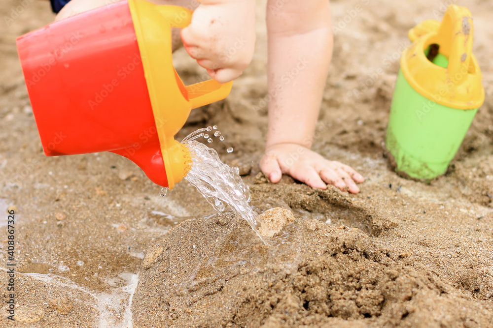 Little boy playing on the beach with plastic toys. Summertime, vacation, travel, childhood concept. Little boy playing on the beach with plastic toys. Summertime, vacation, travel, childhood concept.