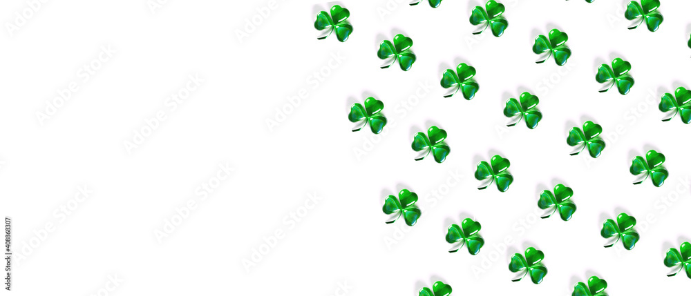 Banner with pattern Shamrock symbols made of green decorative glass hearts lying on white background and copy space. Happy St. Patrick's Day Irish holiday. Spring 17 march lucky clover design Banner with pattern Shamrock symbols made of green decorative glass hearts lying on white background and copy space. Happy St. Patrick's Day Irish holiday. Spring 17 march lucky clover design